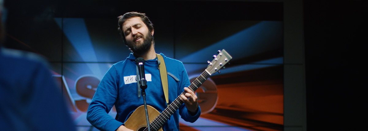 Man auditioning singing and playing guitar