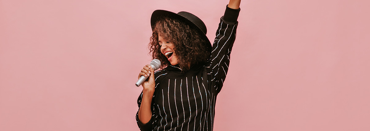 Lady with hat singing with microphone