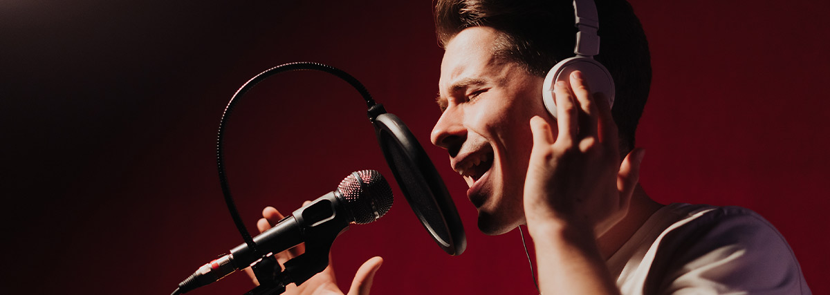 Man with white shirt singing by closing eyes
