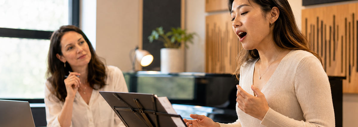 Singing teacher and student practising english singing