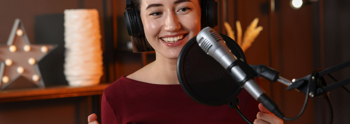 Woman practising English language singing with a microphone and headphones